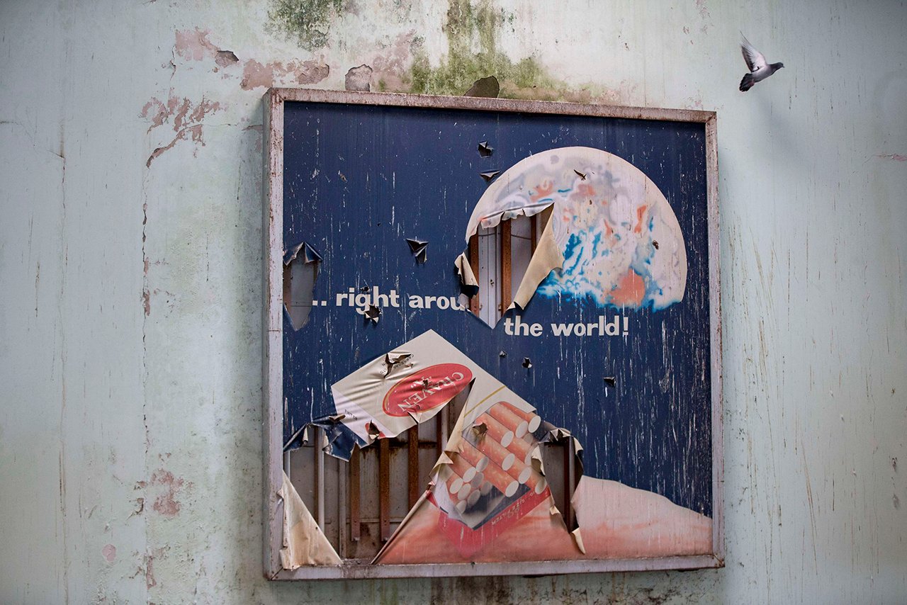 A bird flies past an advertising billboard at the abandoned Nicosia International Airport near Nicosia