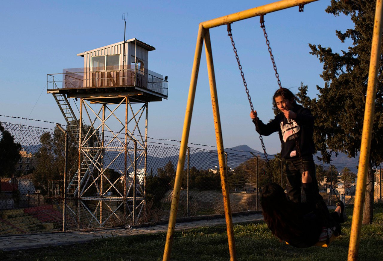 Children play in a park next to a fence marking the United Nations buffer zone in a partially restricted area in the Turkish Cypriot controlled area of central Nicosia