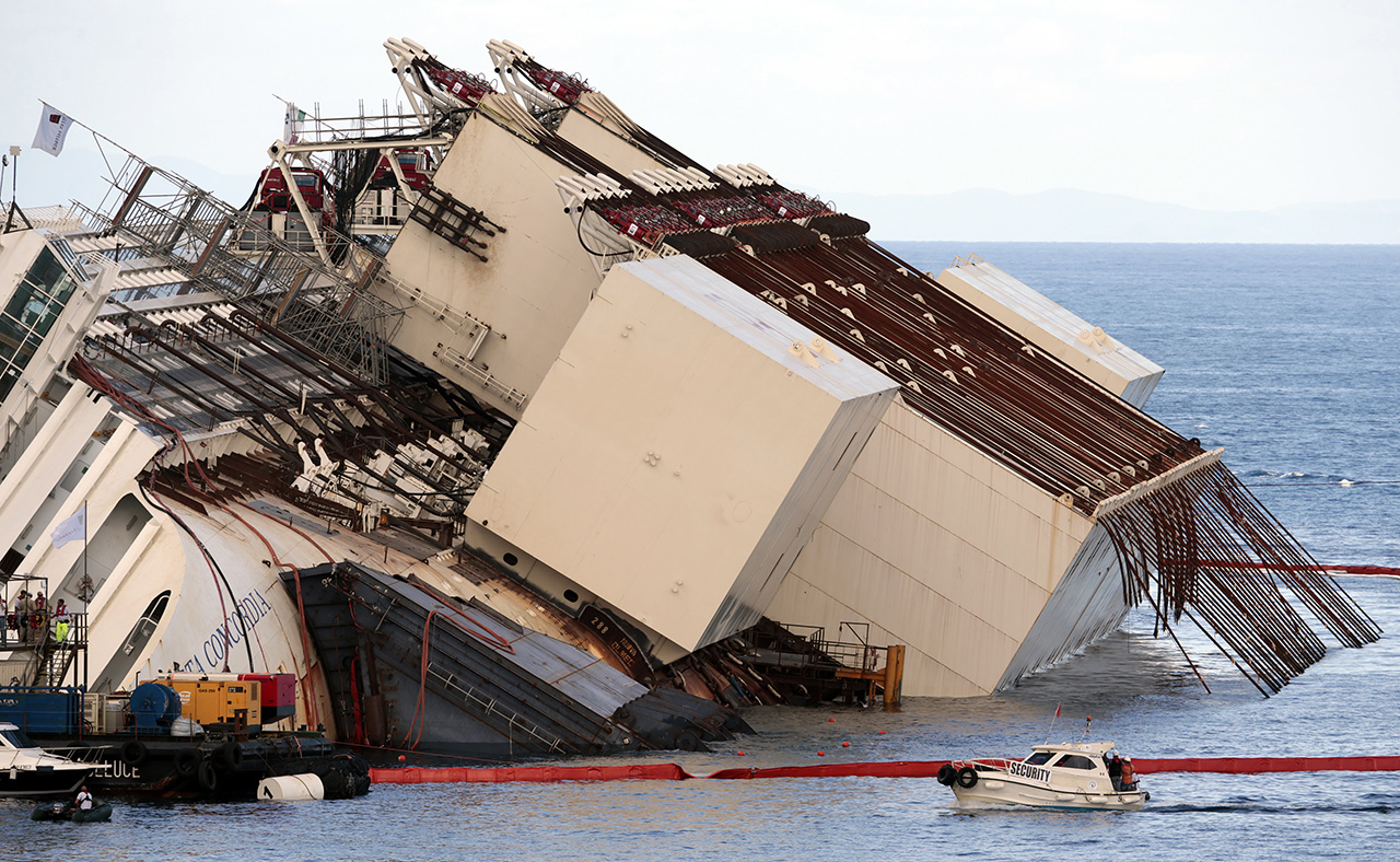 Salvage crew workers are seen in front of the capsized cruise liner Costa Concordia after the start of the 