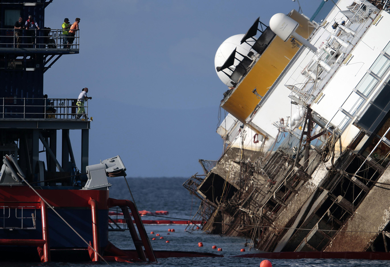 Salvage crew looks at the capsized cruise liner Costa Concordia during the 