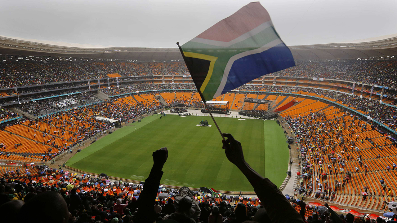 A man waves a South African flag during a memorial service for Mandela in Johannesburg
