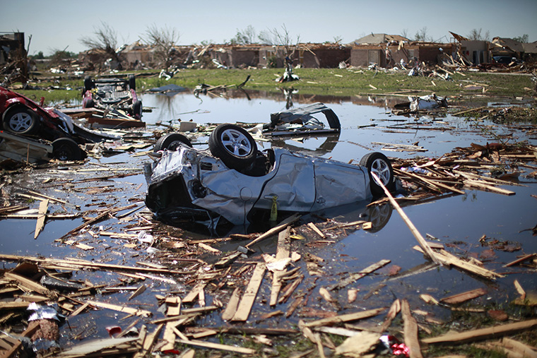 A tornado destroyed car lies upside down in the pond next to Briarwood elementary school in Oklahoma City