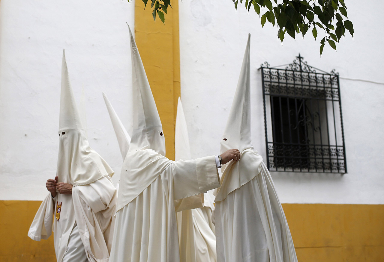 Penitents talk before procession of "La Merced" brotherhood during Holy Week in Cordoba
