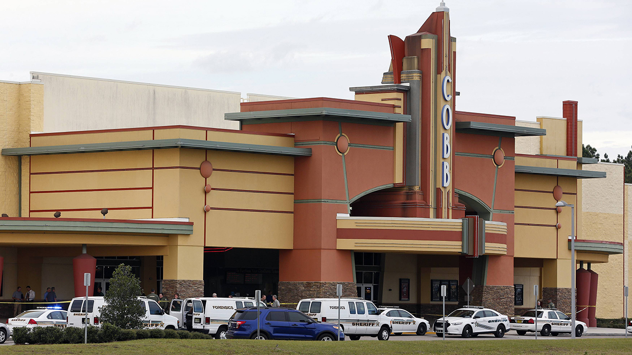 Law enforcement vehicles are parked outside the Cobb Grove 16 movie theater in Wesley Chapel, Florida